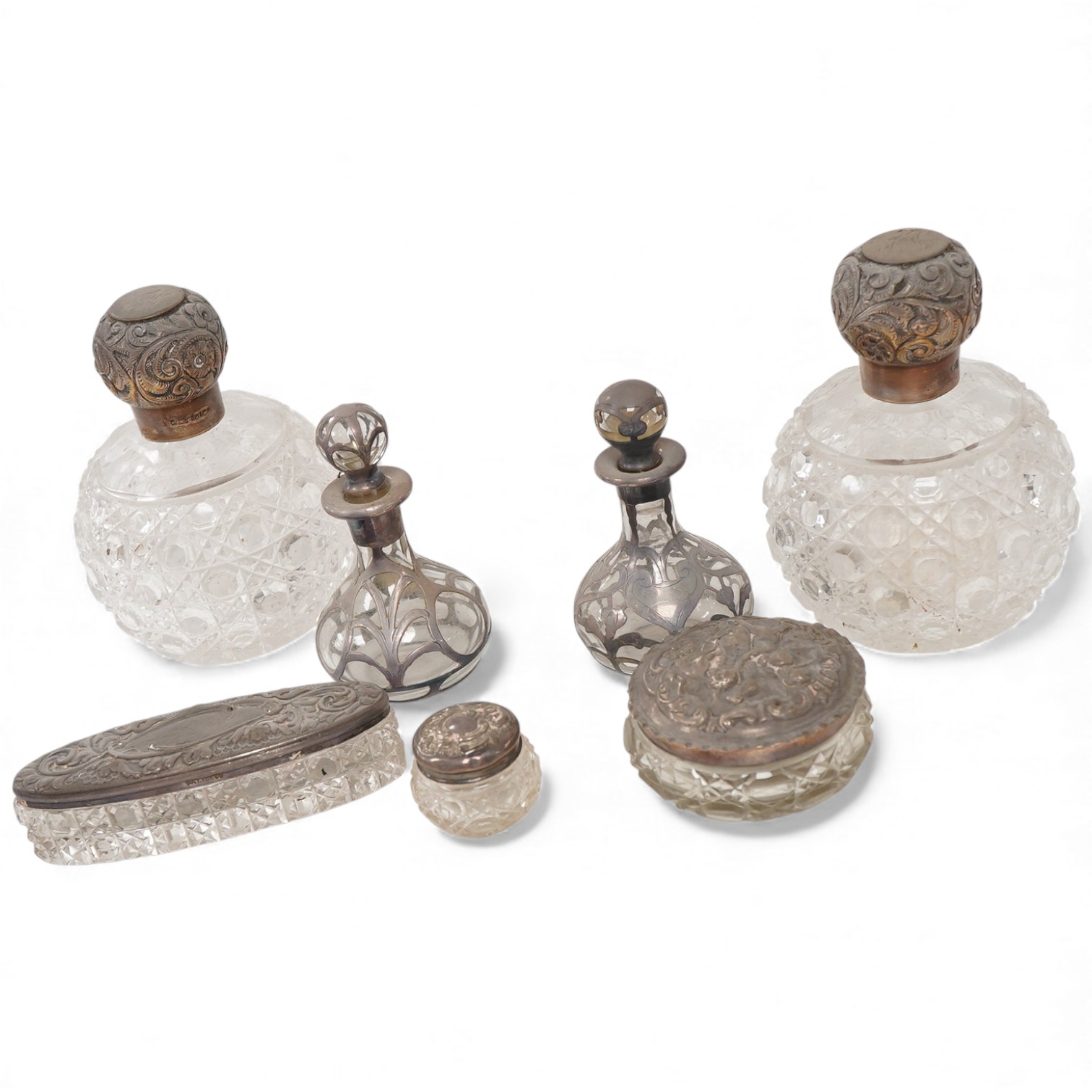 A pair of late Victorian silver mounted cut glass globular scent bottles, by C.C. May & Sons, Birmingham, 1898, height 11.8cm, together with three other silver mounted glass toilet jars and a pair of white metal overlaid